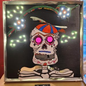 El Niño de la Hélice
Structural Backing • Discount Propeller Cap • Metallic Trim
99¢ Ethic in Action: Repurposed novelty toy elements and hand-cut structural backing join sparkling discount flourishes to create a playful, nostalgic calavera overflowing with youthful reverence.